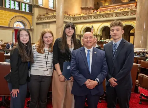 students stand with Assemblyman Burdick in Albany